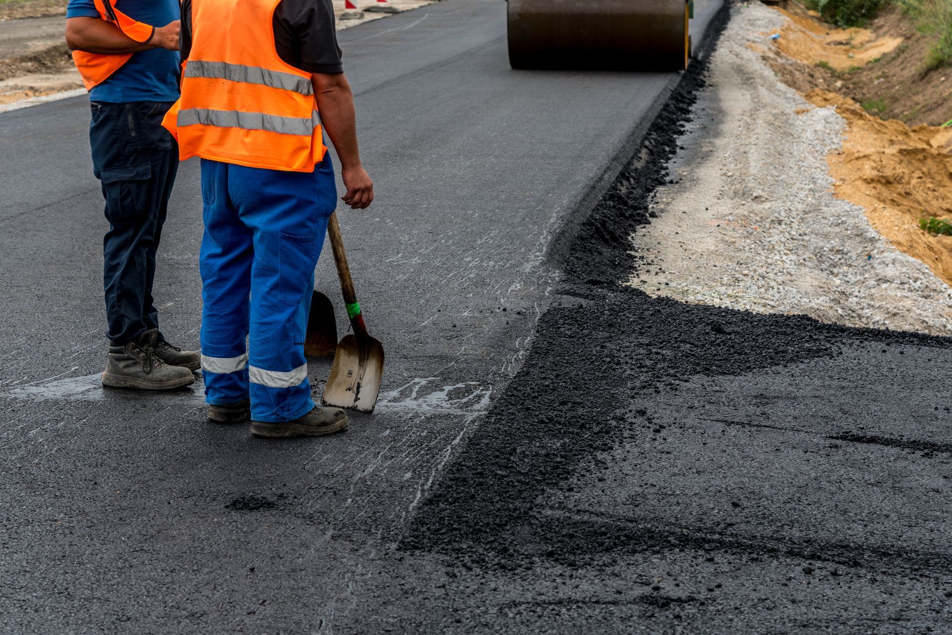 Two Construction Workers Are Standing On The Side Of A Road | Middletown, OH | Affordable Paving Company