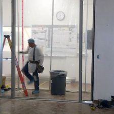 A man is standing next to a ladder in a room.
