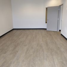 An empty room with a wooden floor and a door.