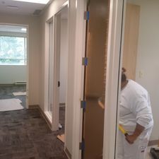 A woman is standing in a hallway holding a tape measure.