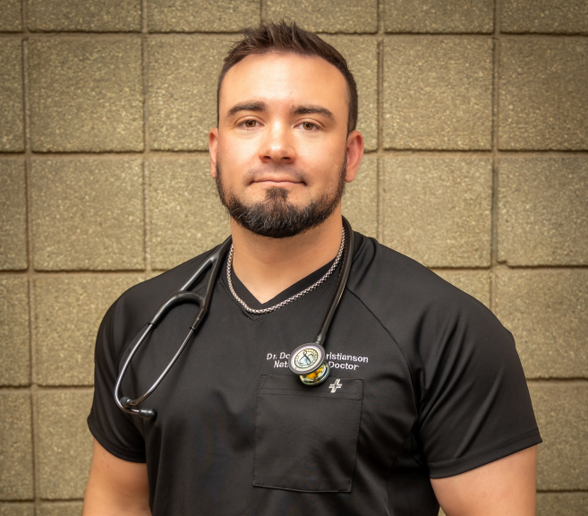 A man with a beard wearing a black shirt and a stethoscope around his neck