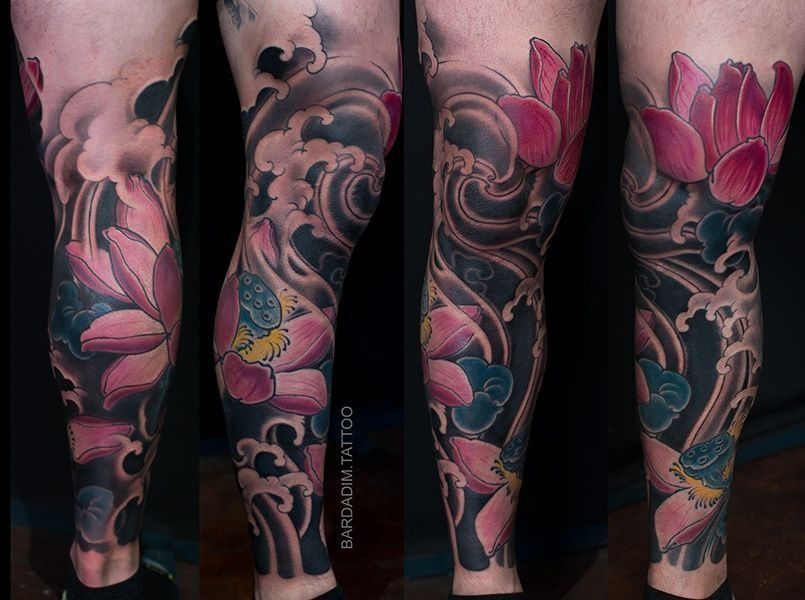 A person with a tattoo on their leg with flowers and waves.