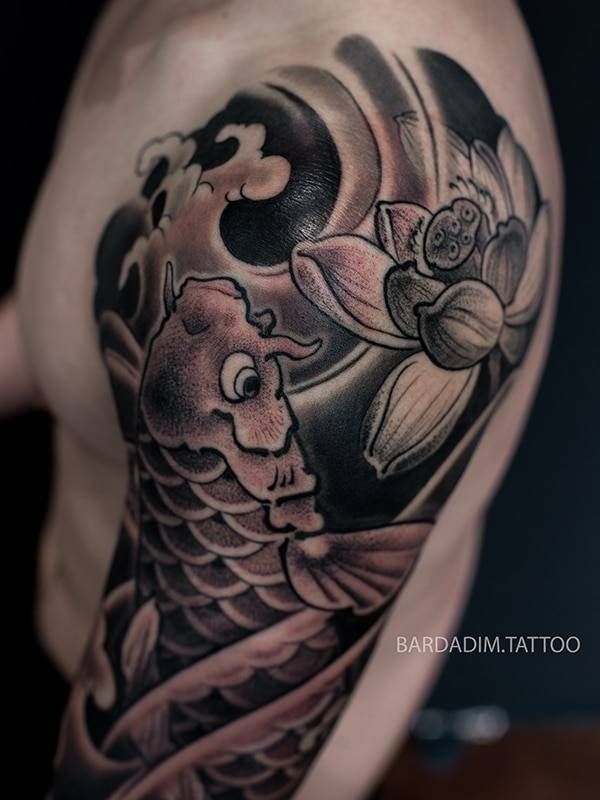 A man has a tattoo of a fish and a flower on his arm
