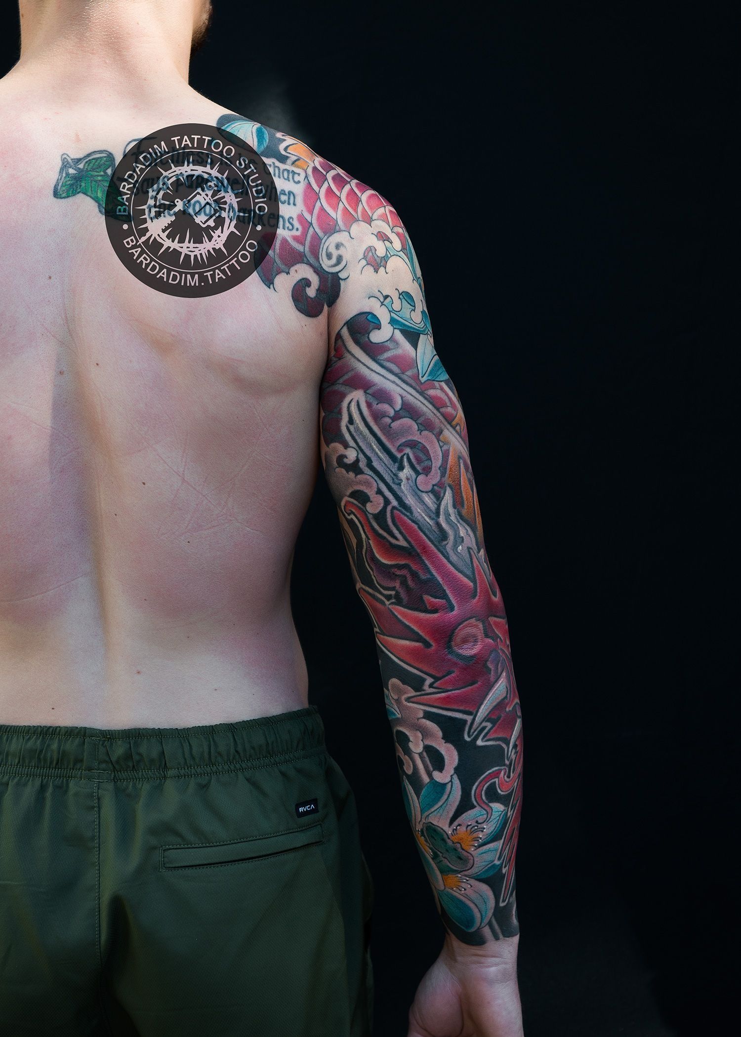 A man with a tattoo on his arm and back.