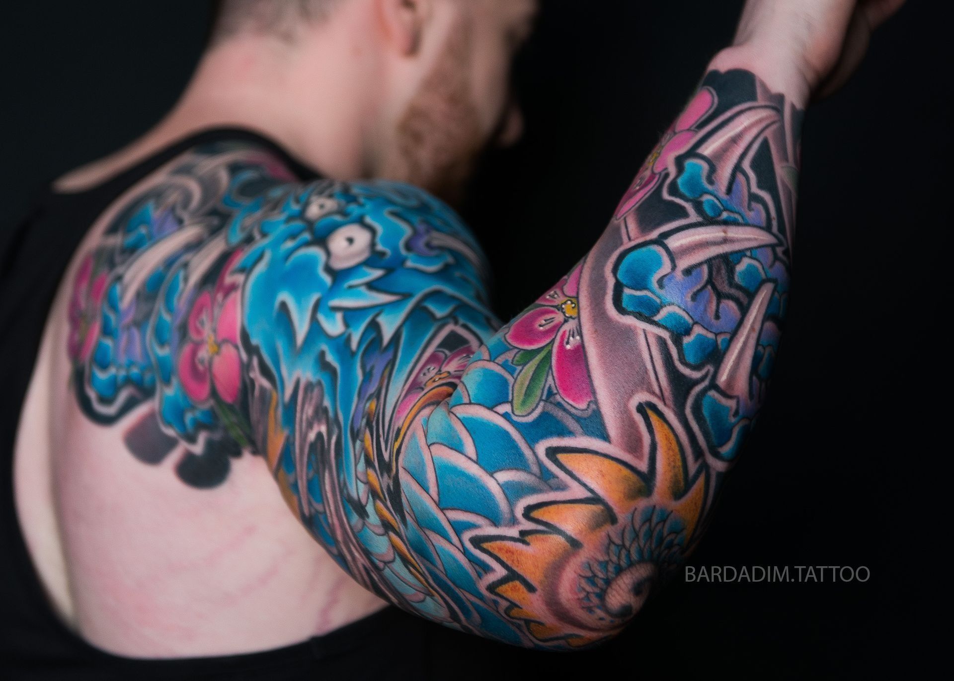A man with a lot of tattoos on his arm and back.