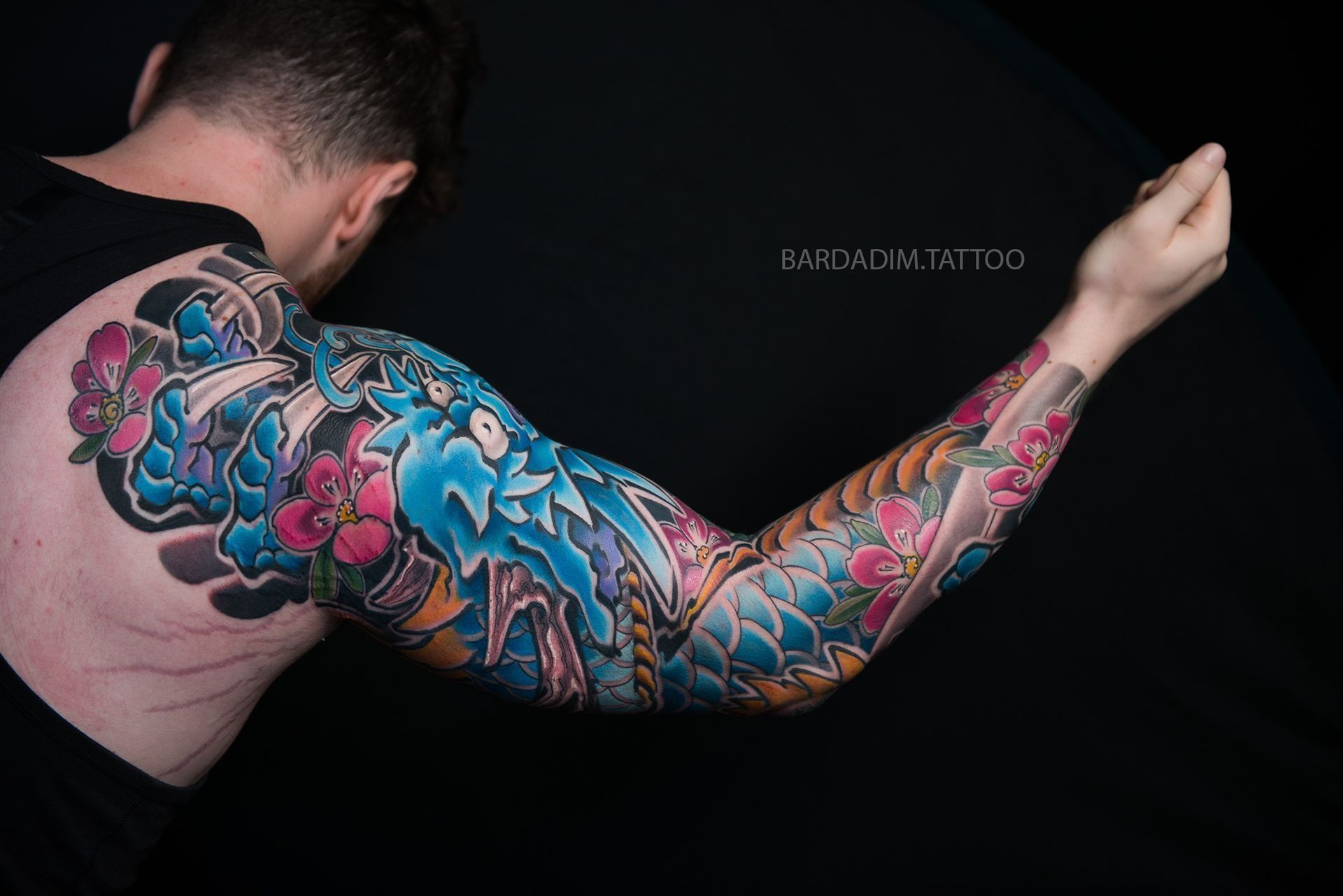 A man with a lot of tattoos on his arm and back.