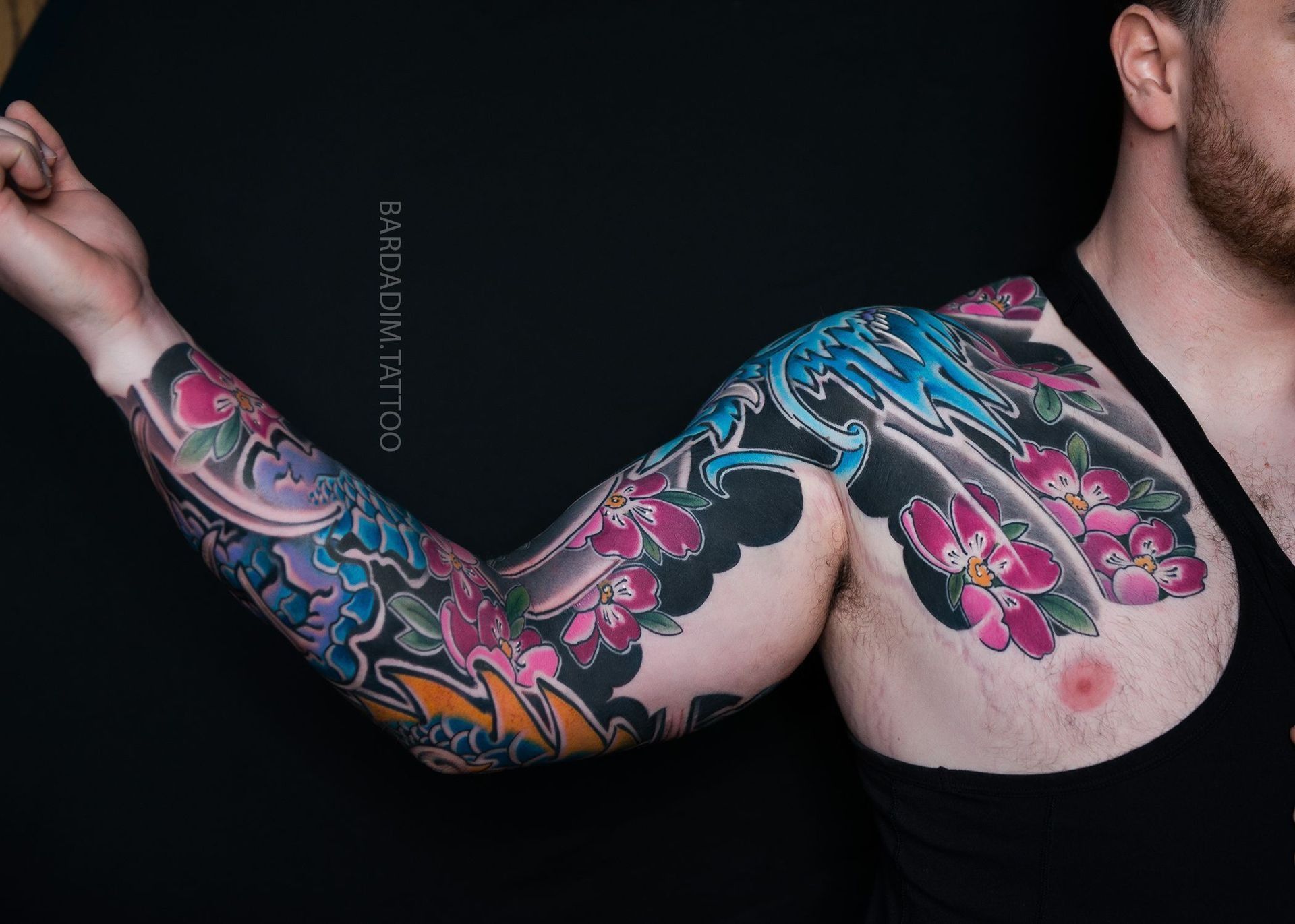 A man with a colorful tattoo on his arm and chest.