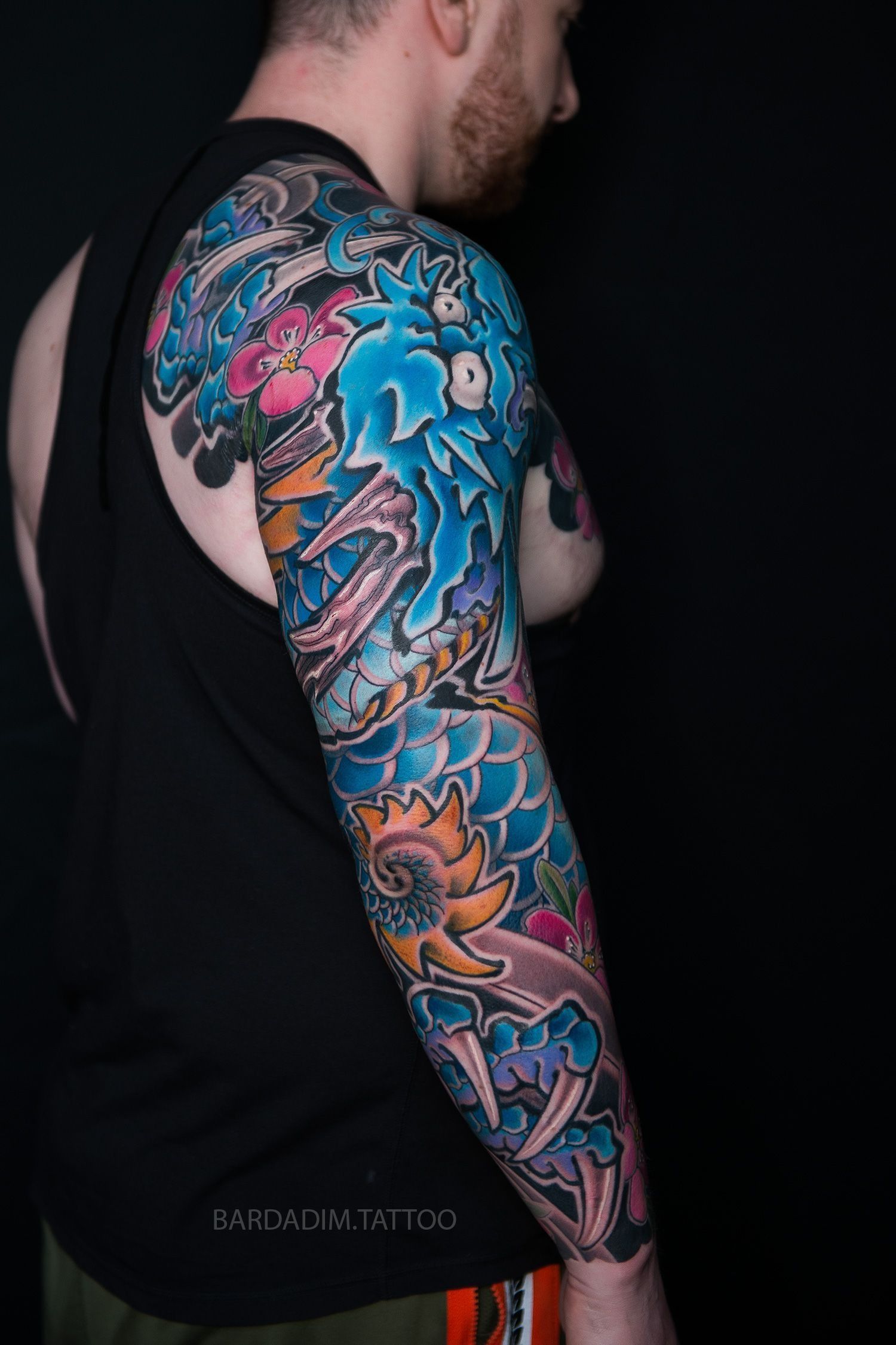 A man with a tattoo on his arm and shoulder.