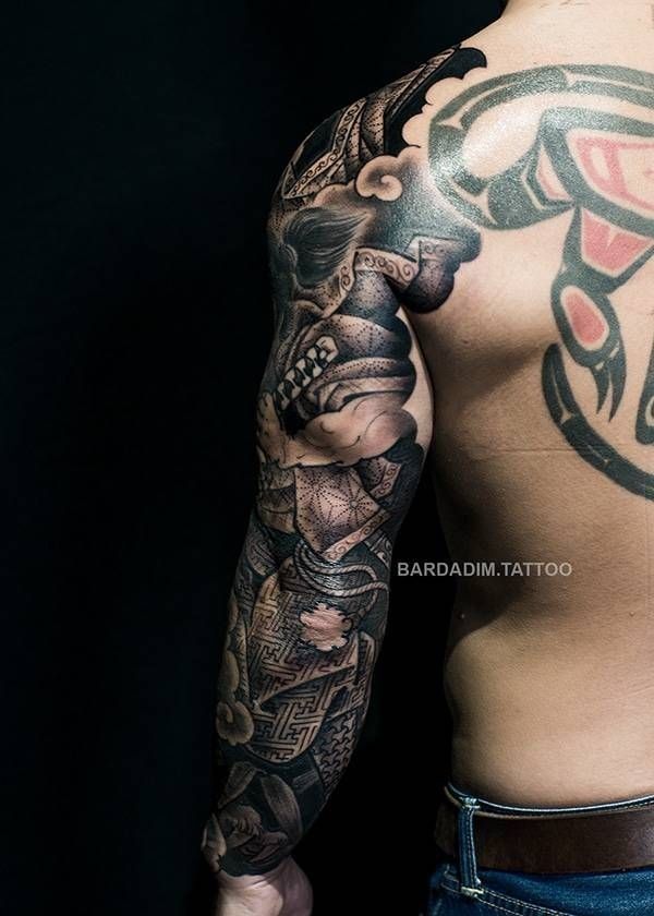 A man with a tattoo on his arm and back.