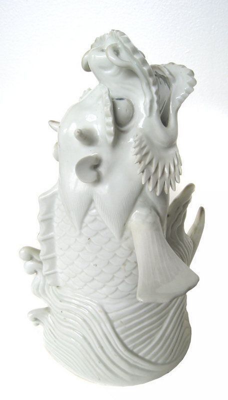White porcelain koi-dragon sculpture, detailed scales, open mouth, and flowing mane.