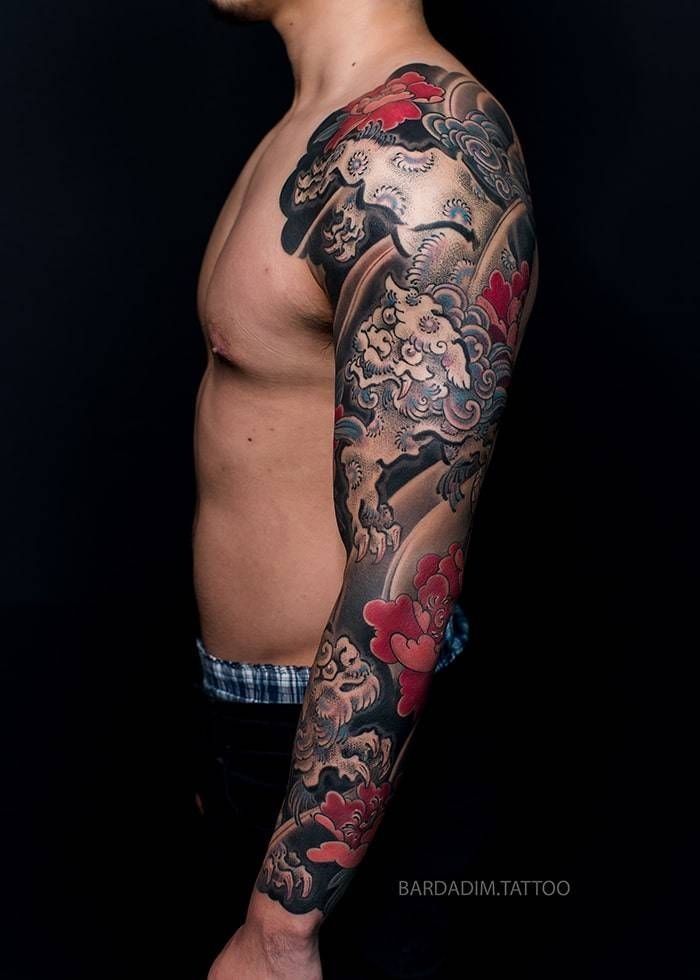 Side view of the shishi sleeve, both lions set in a dark cloud ground with peonies marking the elbow.