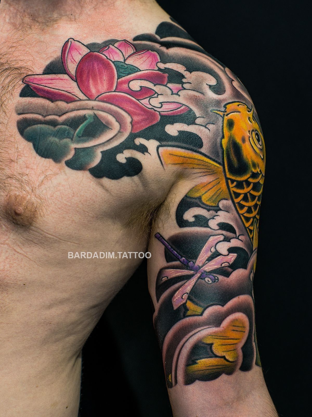 Japanese Irezumi Tattoo of a koi fish and lotus flower on a person's arm and shoulder, in shades of yellow, pink, and black. NYC.