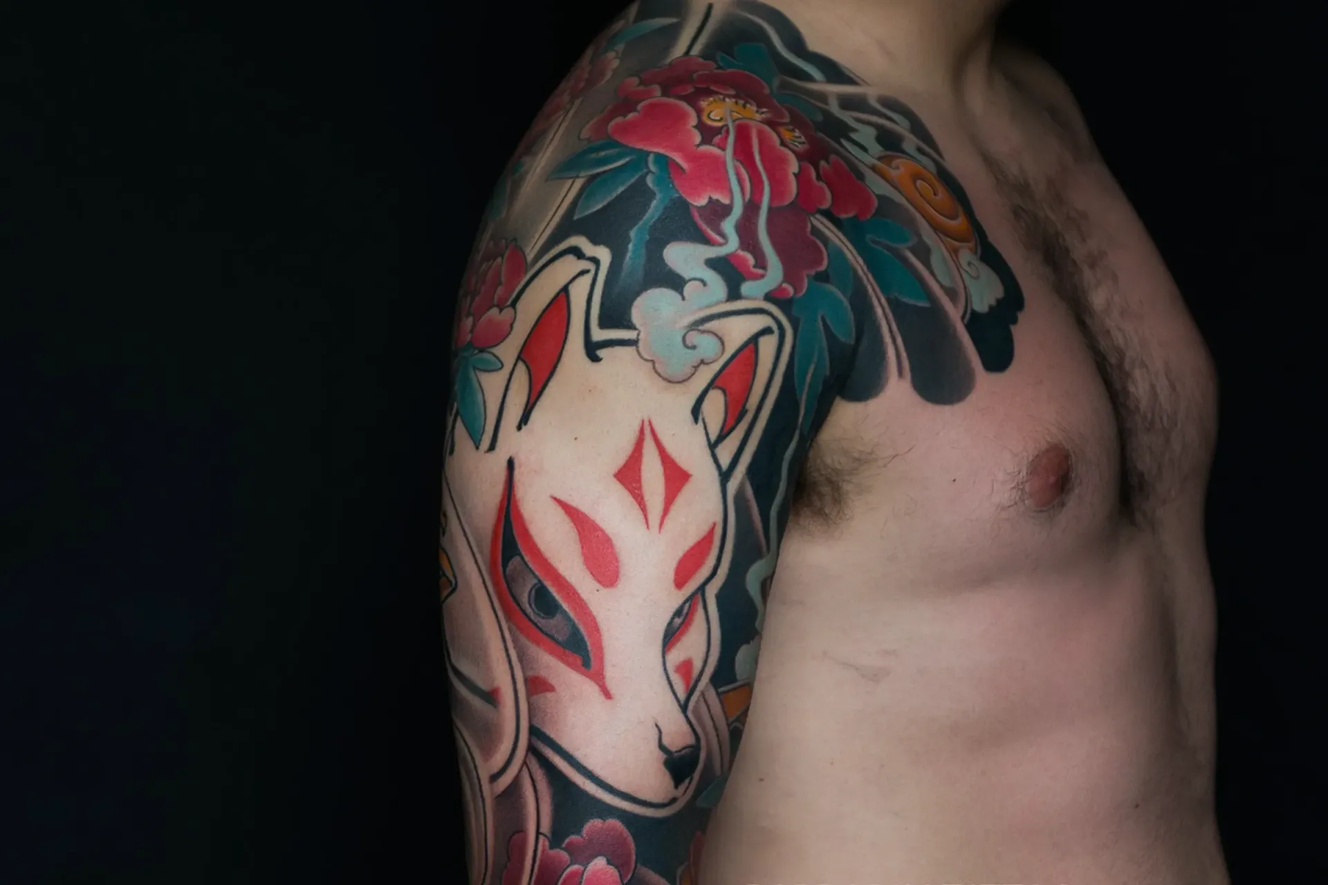 Full sleeve Japanese tattoo featuring kitsune mask and peony flowers, detailed irezumi arm tattoo