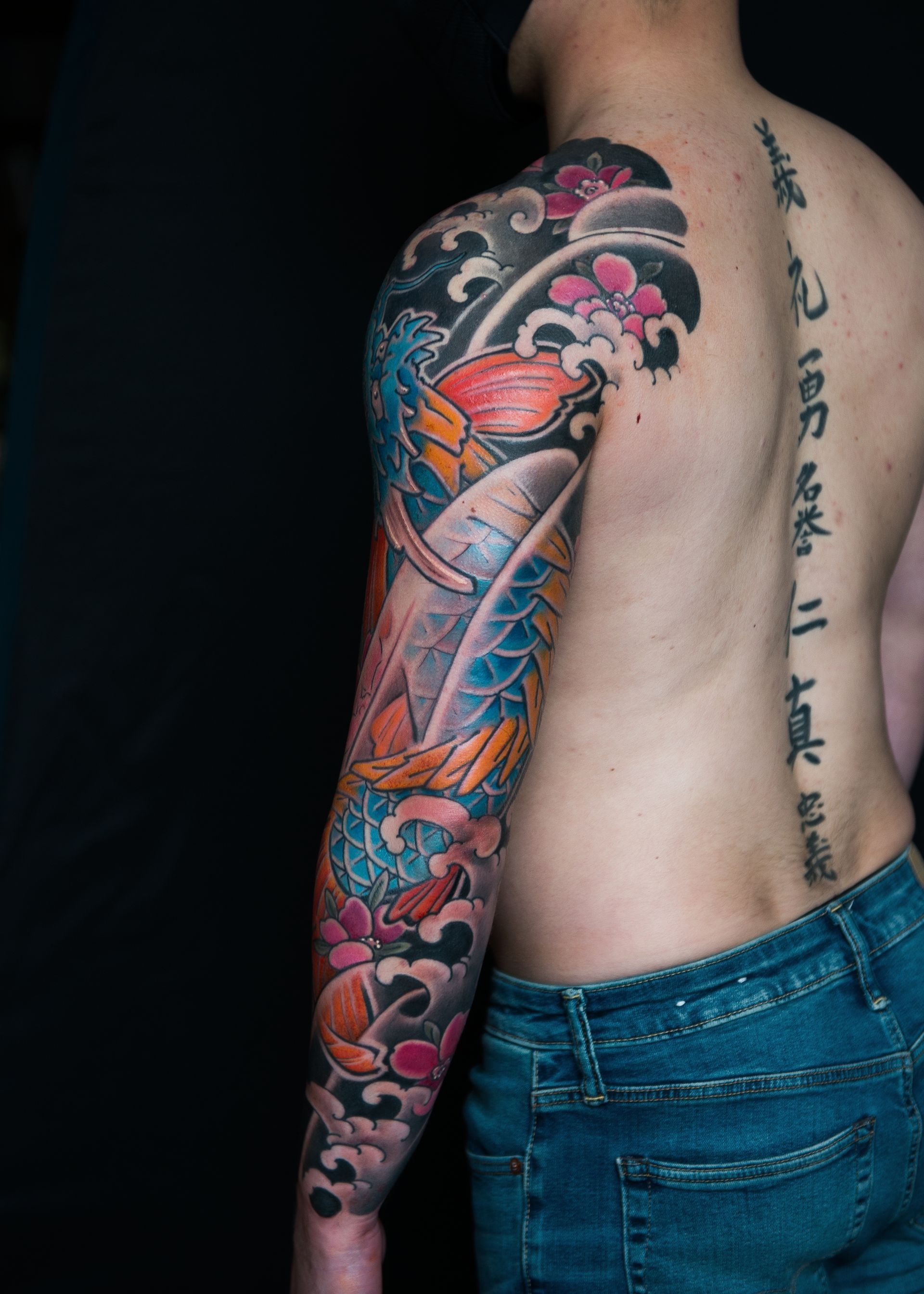 A man with a tattoo of Koi-Dragon and cherry blossoms. Tattoo by George Bardadim.