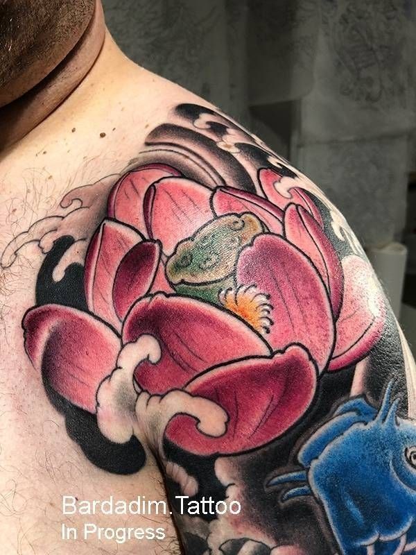 A man has a tattoo of a lotus flower on his shoulder.