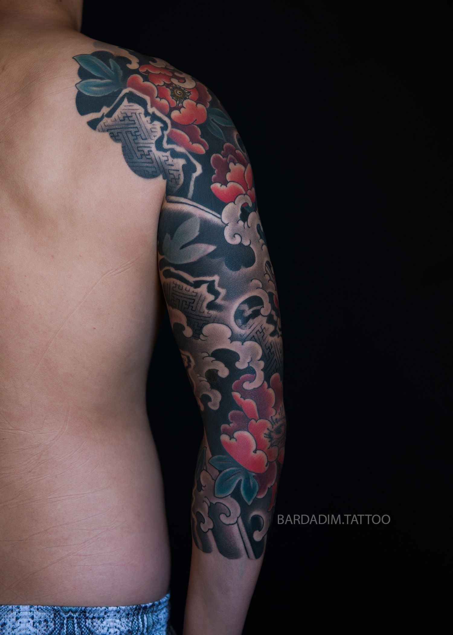 A man with a tattoo on his arm and shoulder.