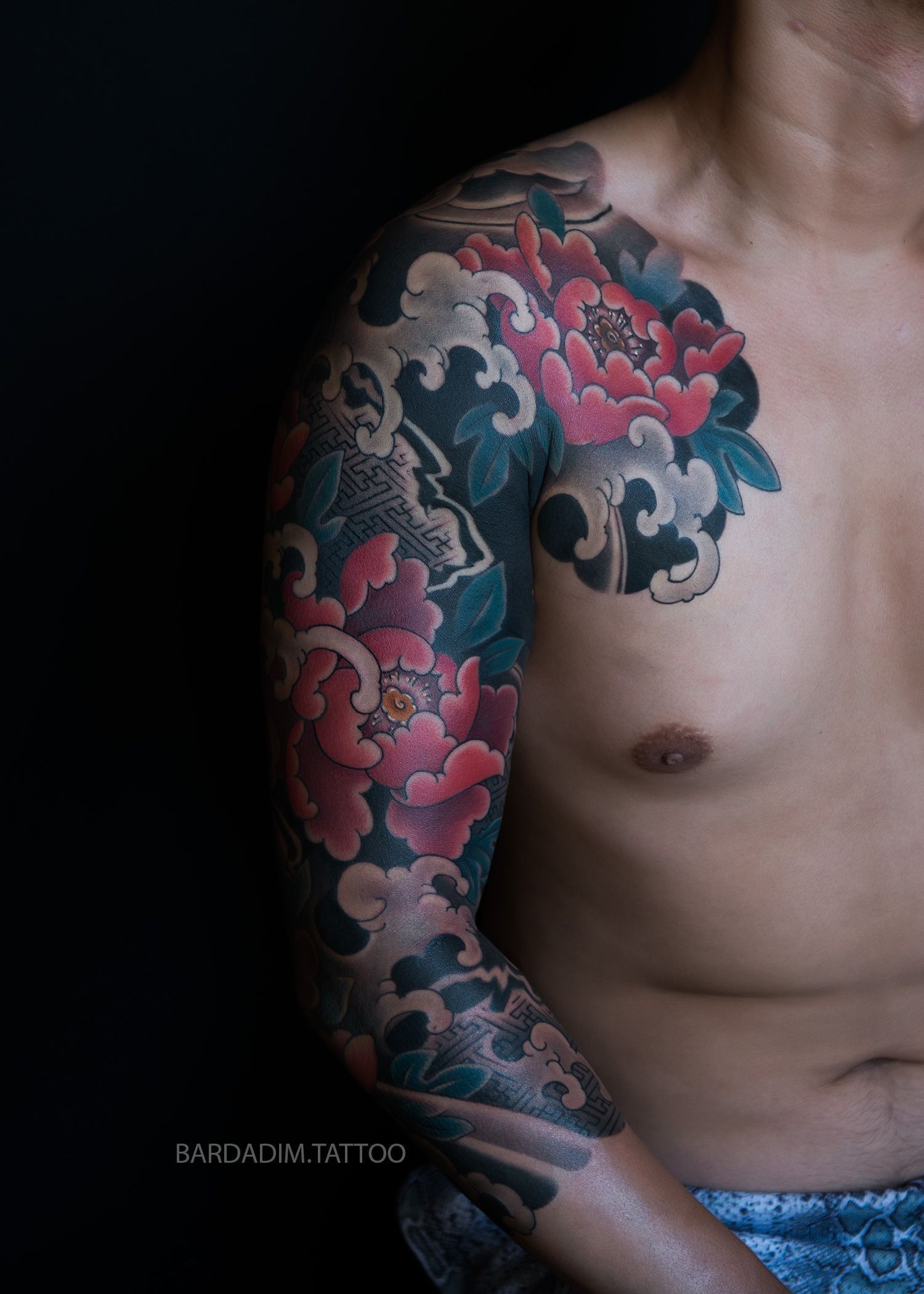 A man with a tattoo on his arm and chest.