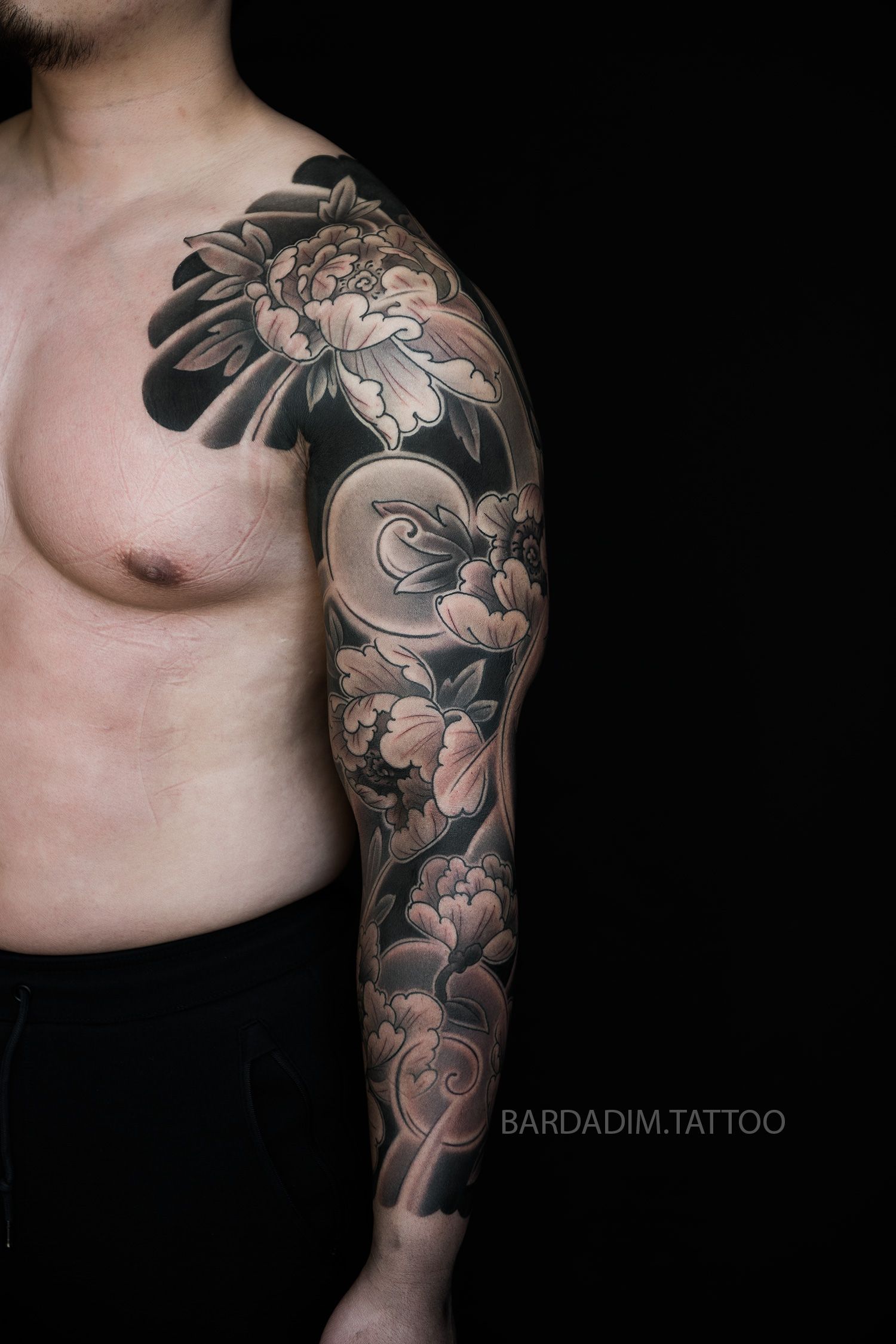 Three-quarter view of the white peony Japanese sleeve by Bardadim with prominent shoulder flower and clean anatomical flow.