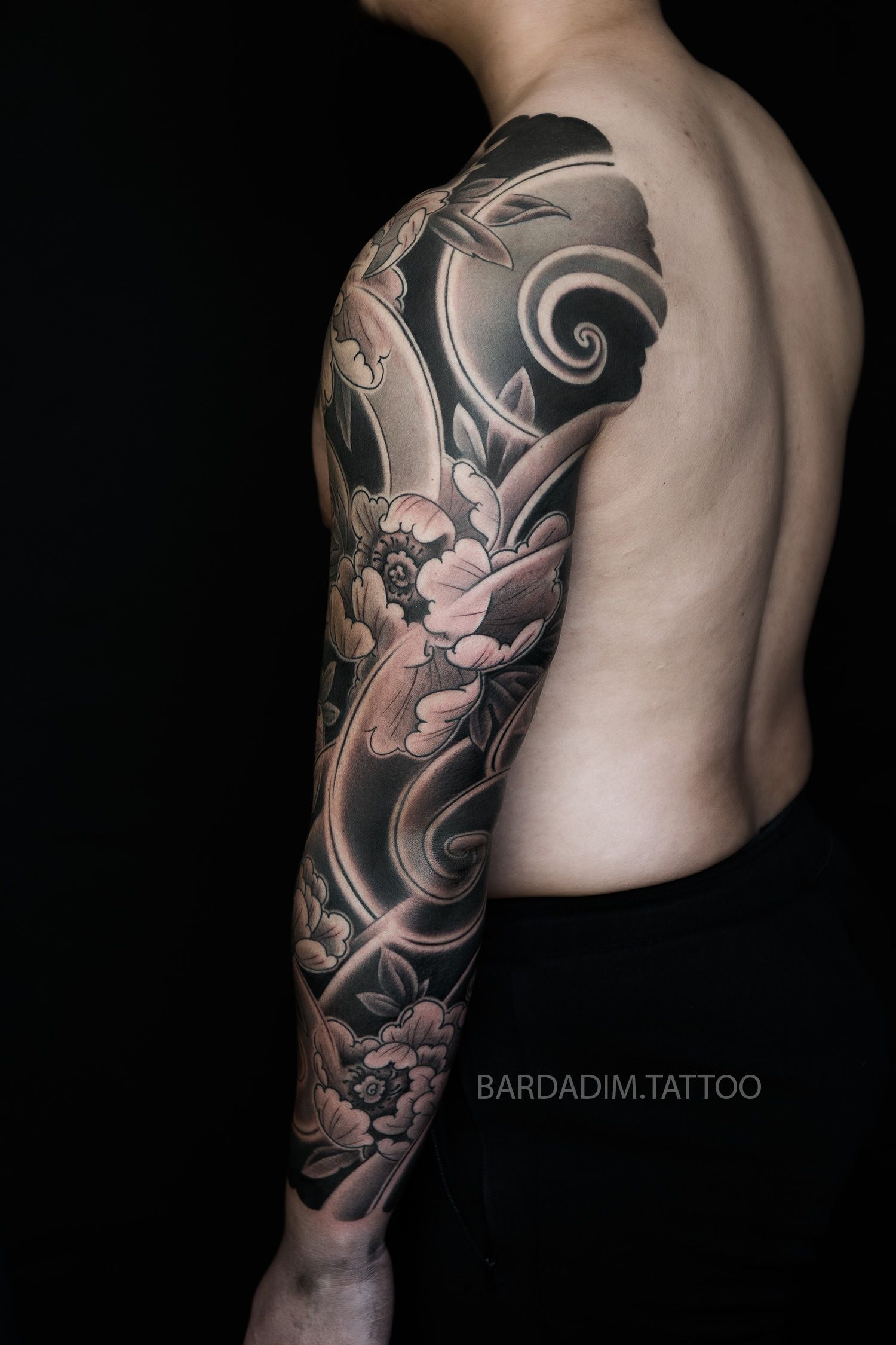 Side profile of Bardadim’s Japanese peony sleeve showing flowing background shapes and refined black-and-grey gradients.