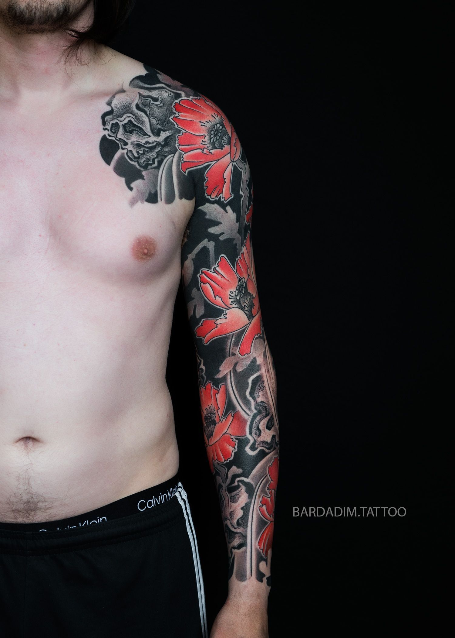 A man with a tattoo on his arm and chest