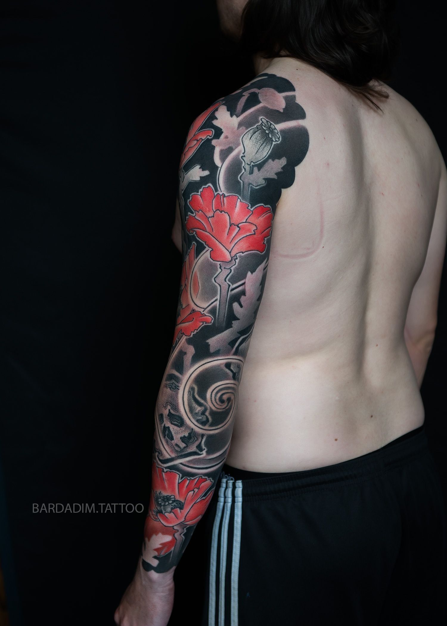 A man with a full sleeve tattoo on his arm.