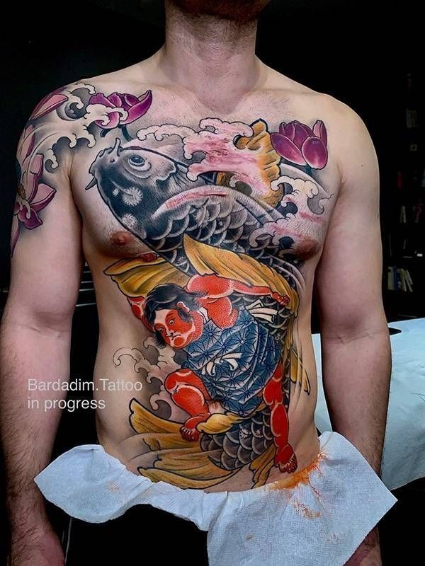 A man has a tattoo of a fish on his chest