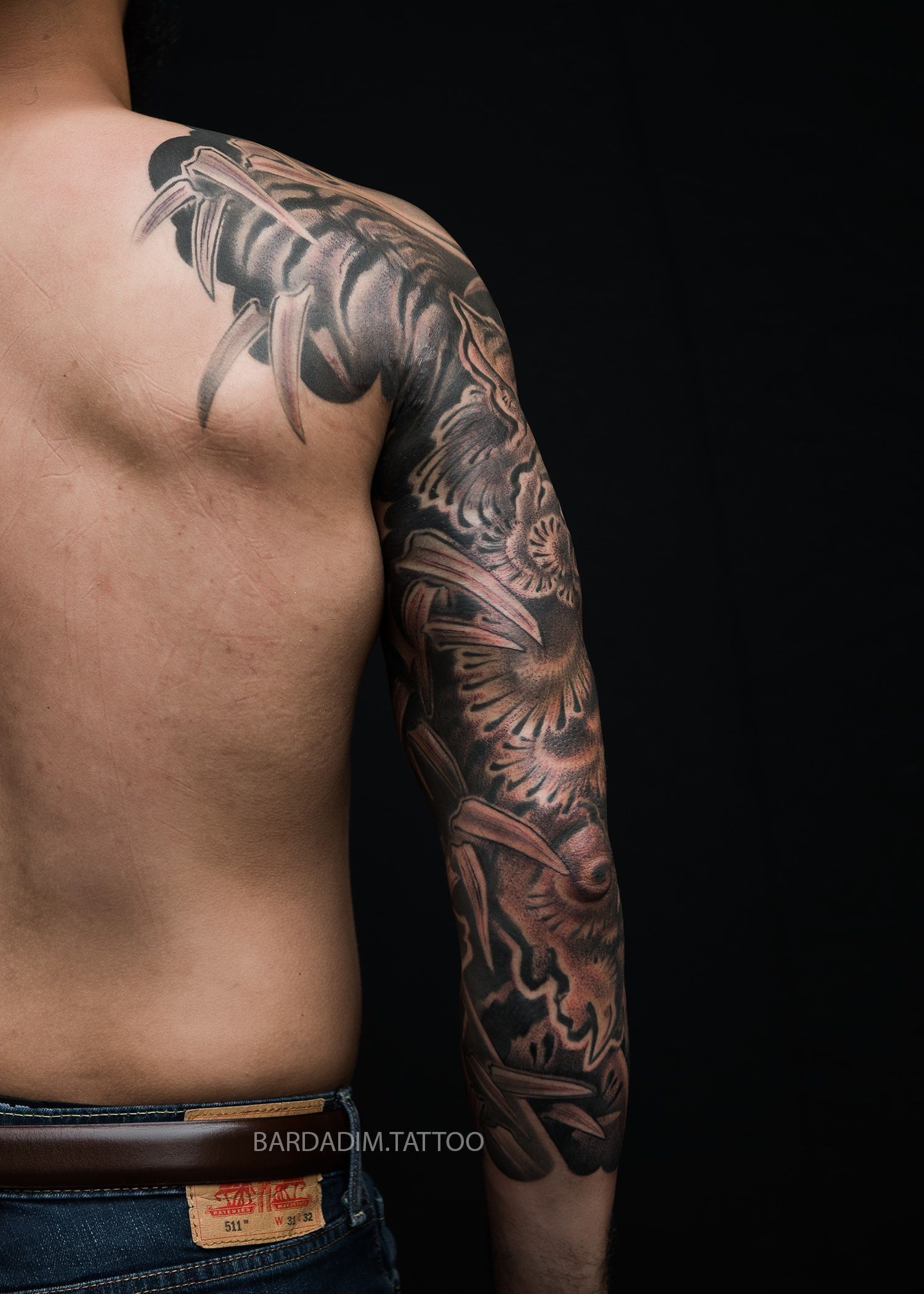A man with a tattoo on his arm and shoulder.