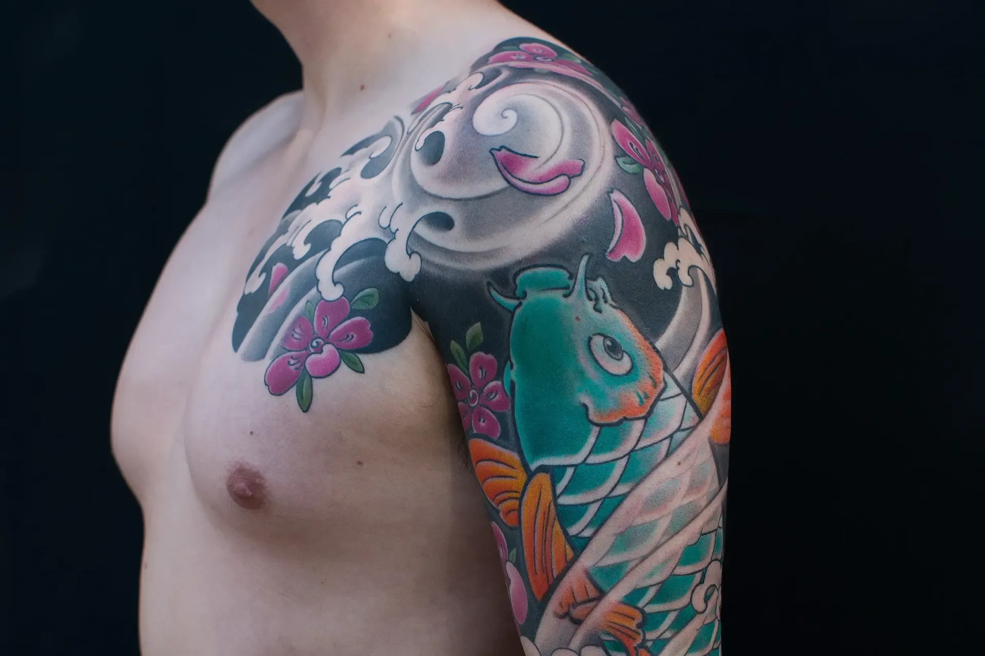 Japanese sleeve tattoo showing anatomical flow — koi and waves following natural muscle lines