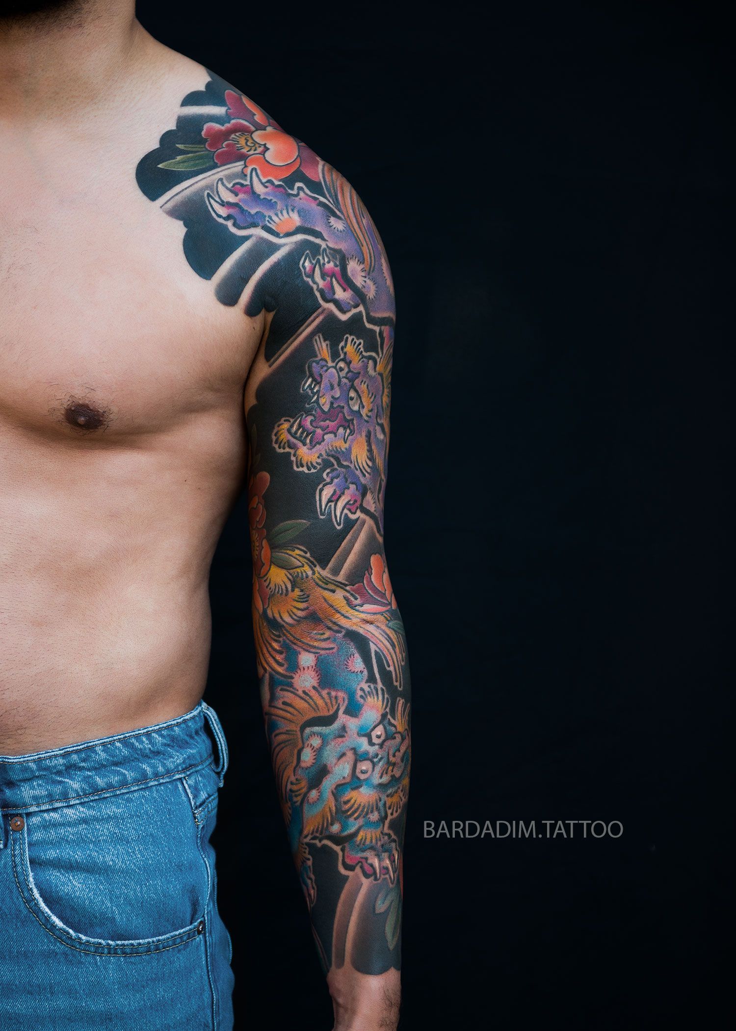 Front view of full Irezumi sleeve showing paired Shishi guardian lions and floral peony background in traditional Japanese tattoo style.