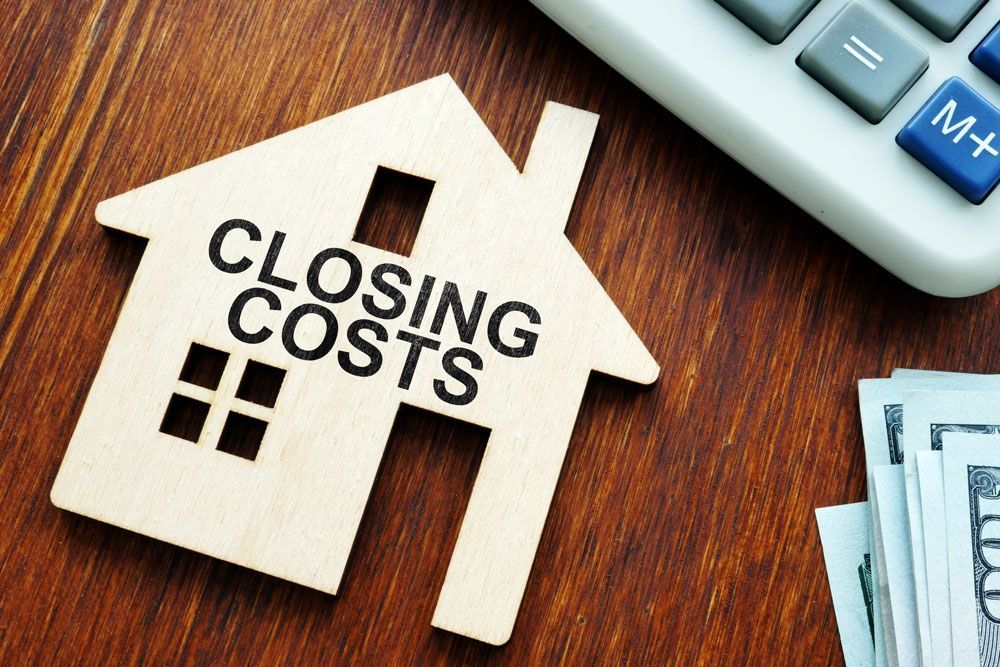a wooden house with the words closing costs written on it