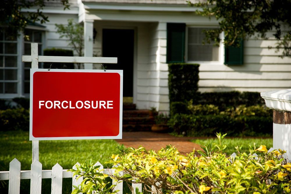 a forclosure sign in front of a white house
