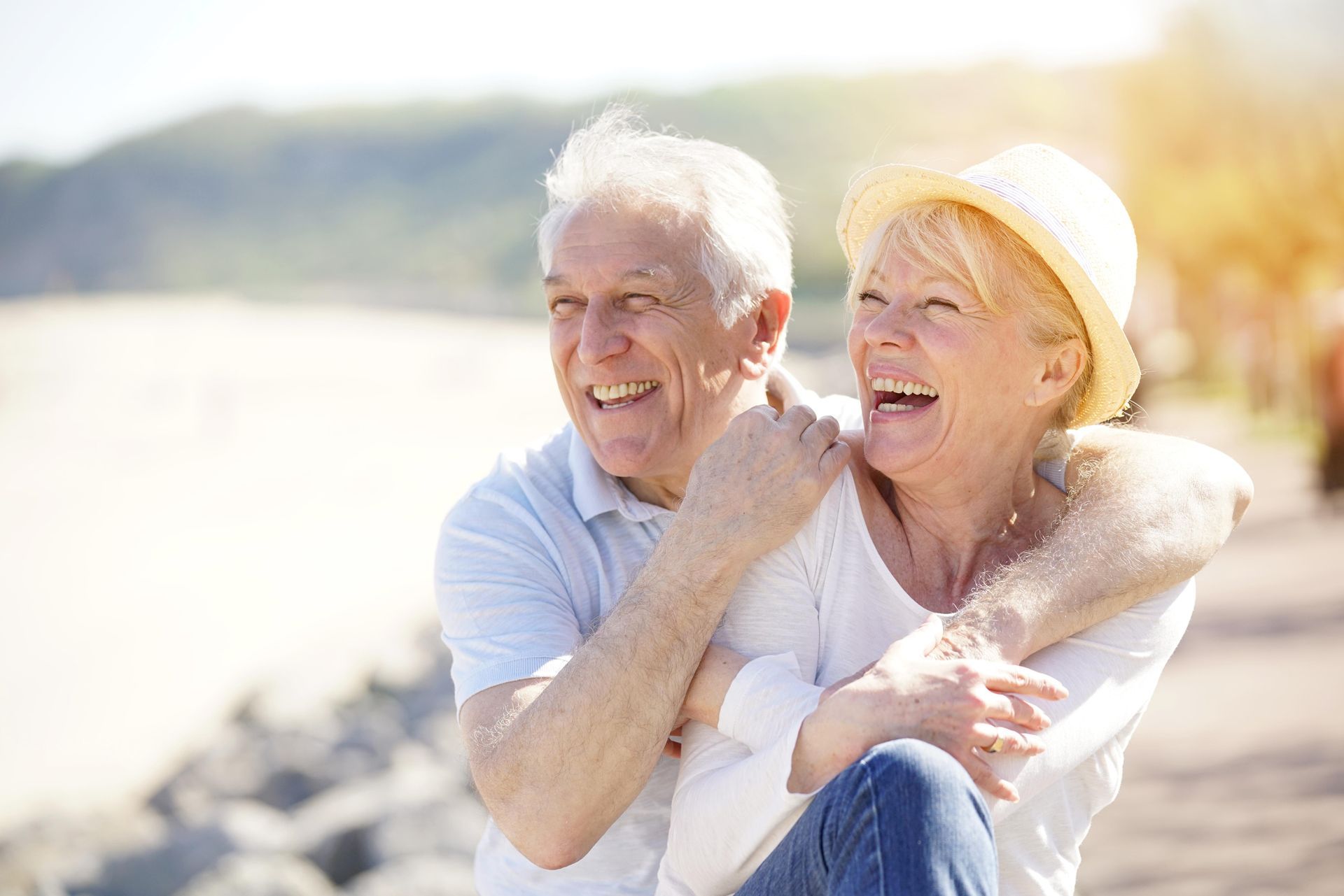 a man is giving a woman a piggyback ride on the beach .