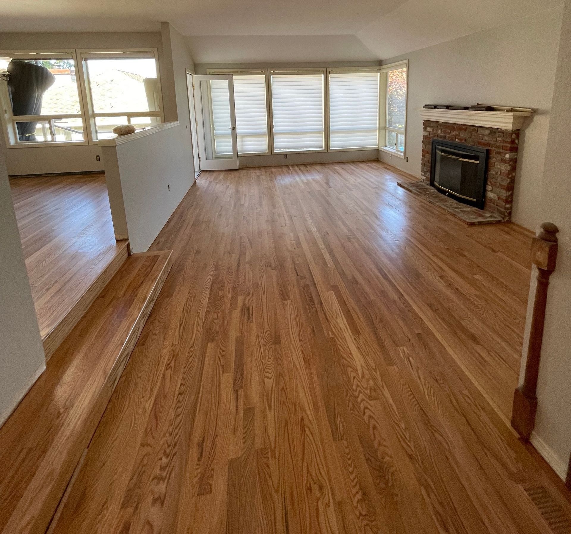 A living room with hardwood floors and a fireplace