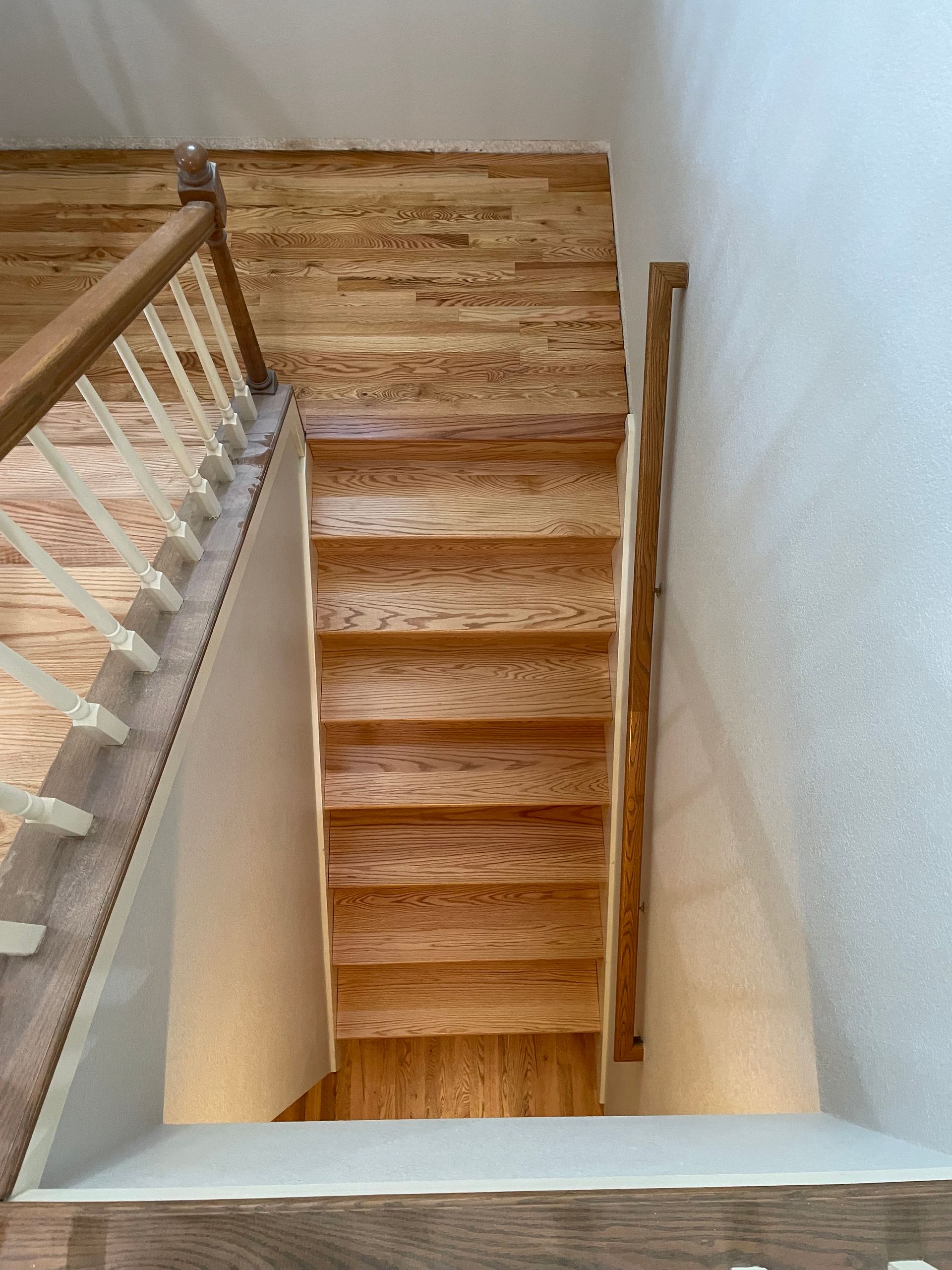 A view of a wooden staircase from the second floor.