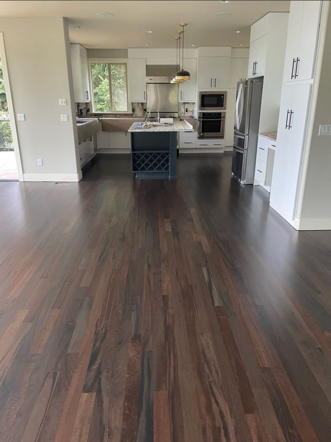 A kitchen with a wooden floor and white cabinets.