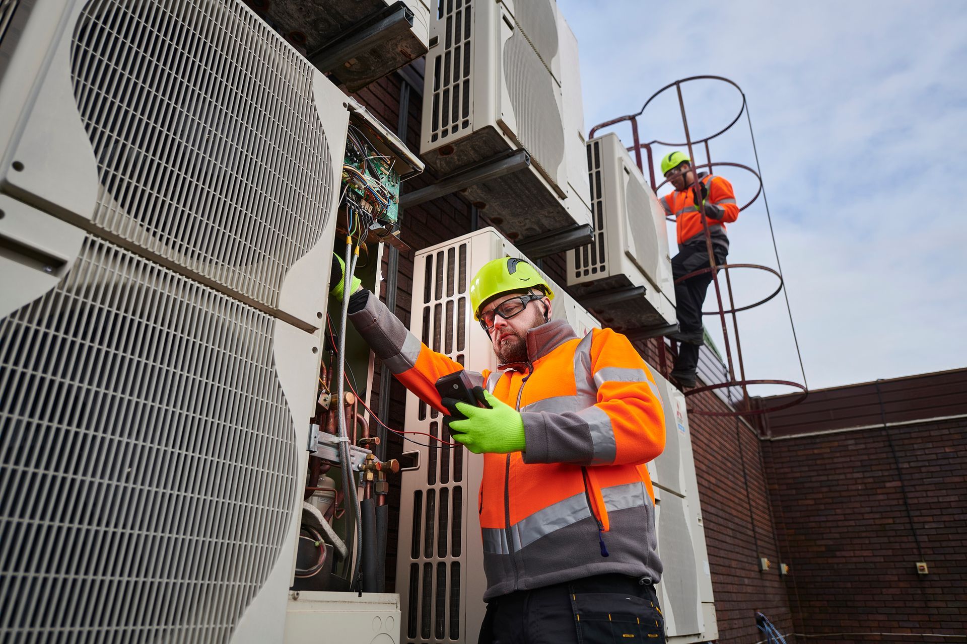 Air conditioning engineers servicing on top a commercial building. Air conditioning engineers servicing on top a commercial building.