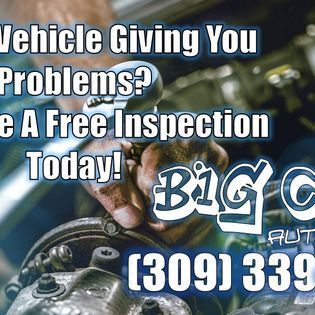 Advertisement for Big C Auto, offering free vehicle inspections. Shows a mechanic working on a vehicle. Phone number is visible.