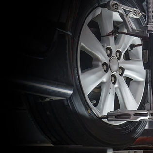 Car wheel being aligned, with equipment attached; close-up view.