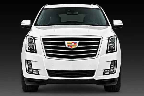 Front view of a white Cadillac SUV on a dark background