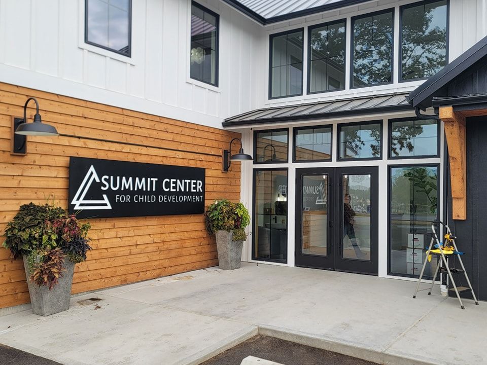 Summit Center building entrance with glass doors and orange wood siding