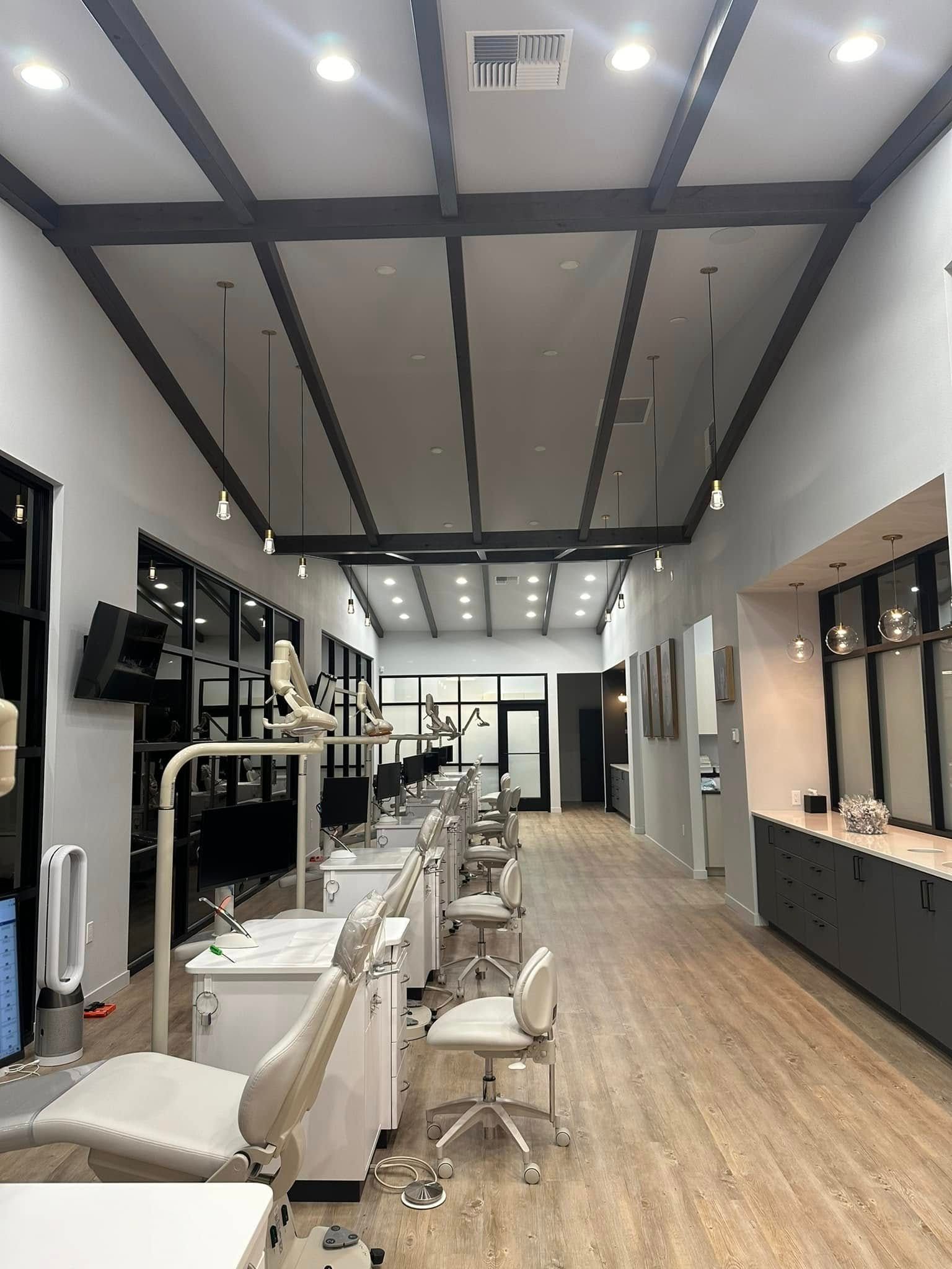 Modern salon interior with styling chairs, mirrors, and wood floors under bright ceiling lights