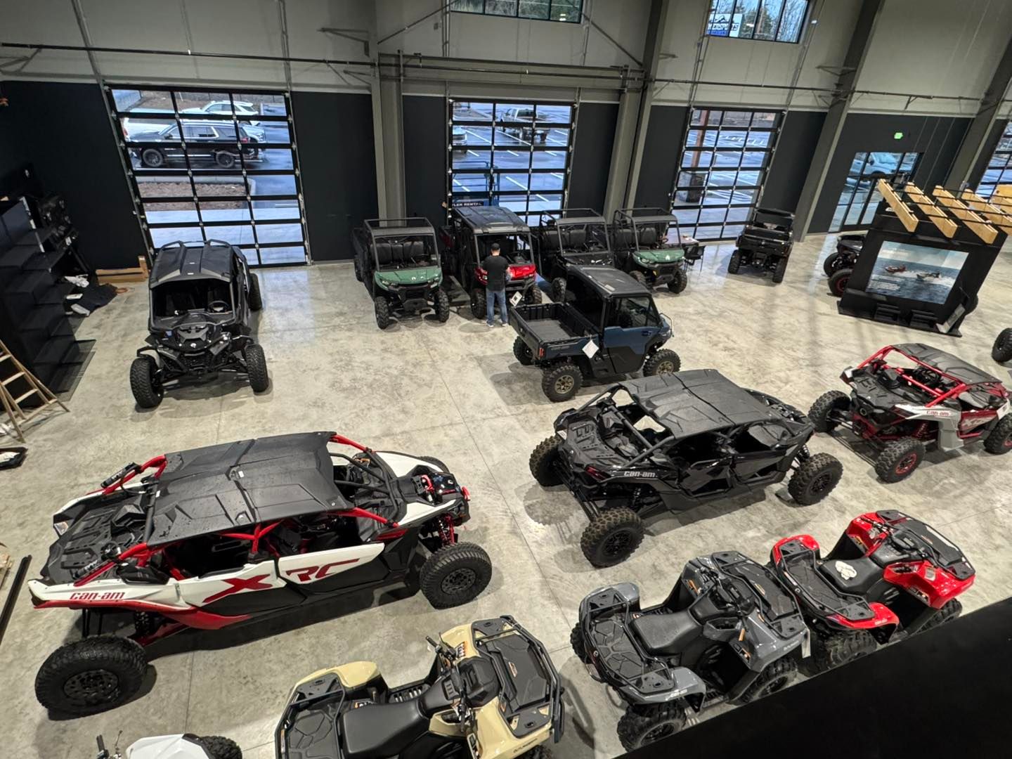 Multiple off-road side-by-side vehicles and dune buggies parked in a warehouse-like garage.