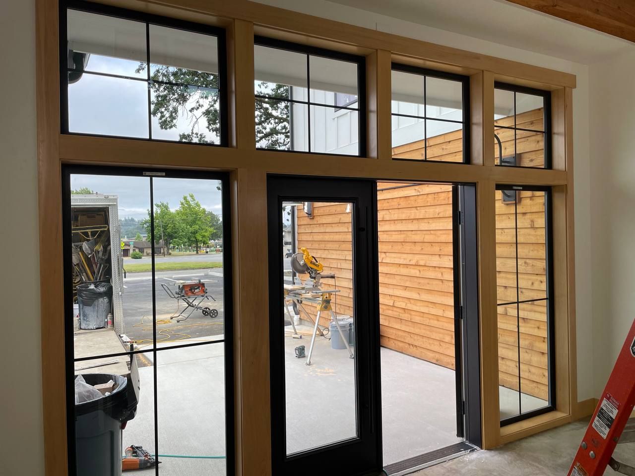 Interior view of glass patio doors and windows overlooking a patio, street, and orange exterior wall