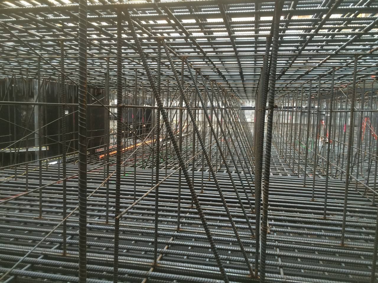Steel rebar framework of a large construction site, viewed from inside the structure.