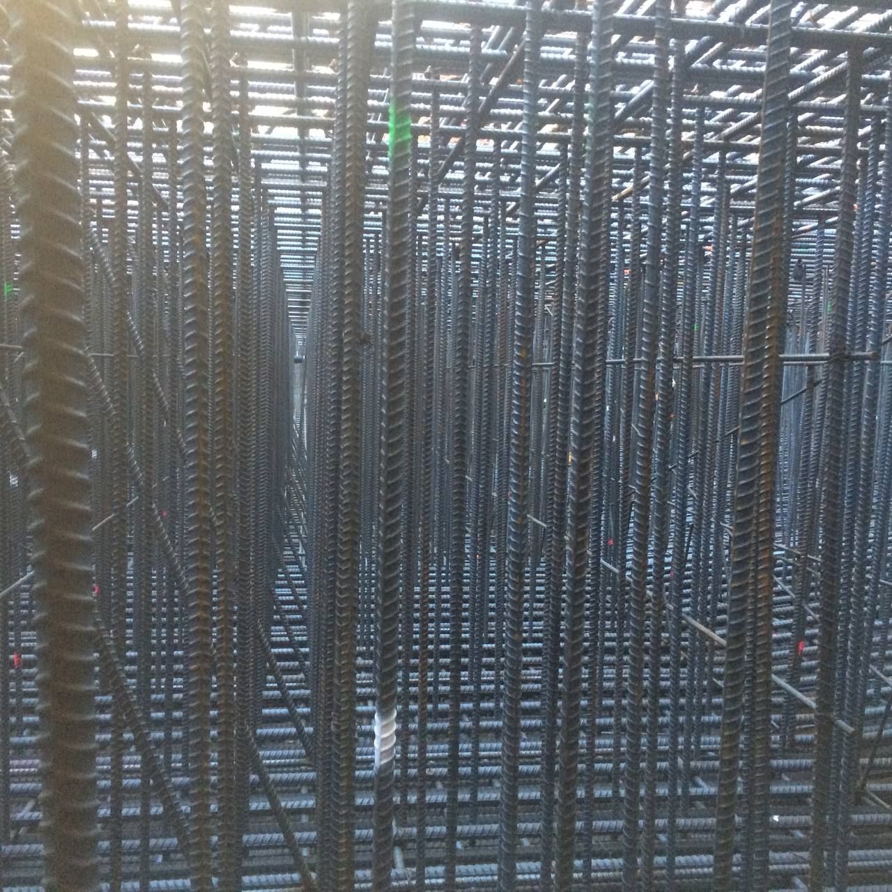 Dense grid of stacked metal bars, creating a repeating industrial pattern.