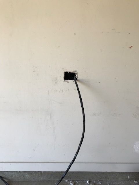 A black cord is plugged into a wall outlet