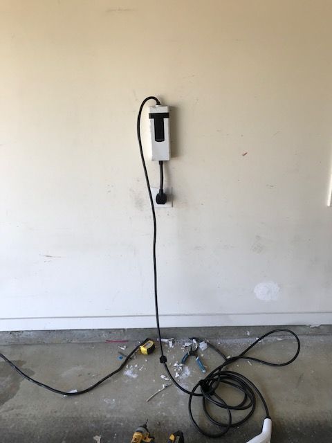 A power cord is plugged into a wall outlet