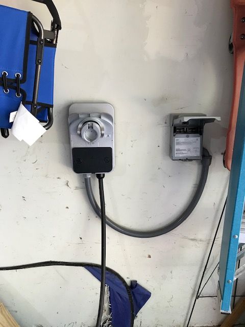 A timer is plugged into a wall next to a ladder