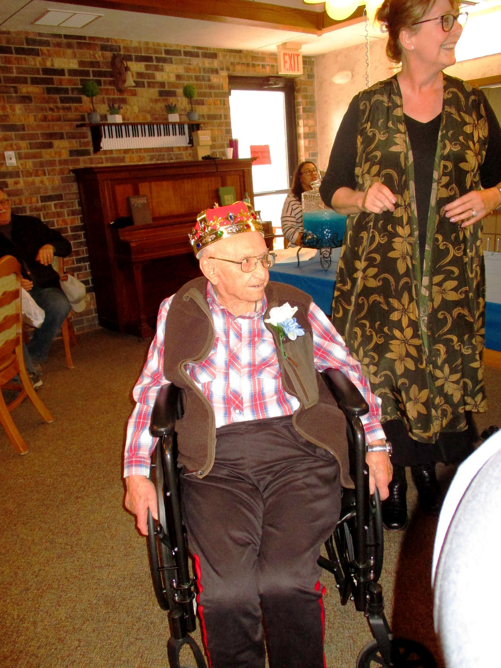 A man in a wheelchair with a crown on his head