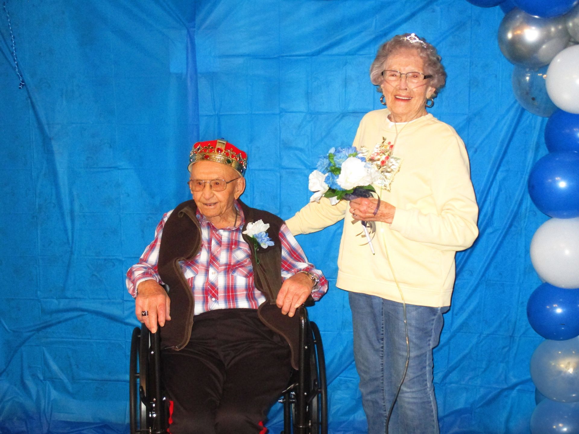 A woman is holding a bouquet of flowers next to a man in a wheelchair